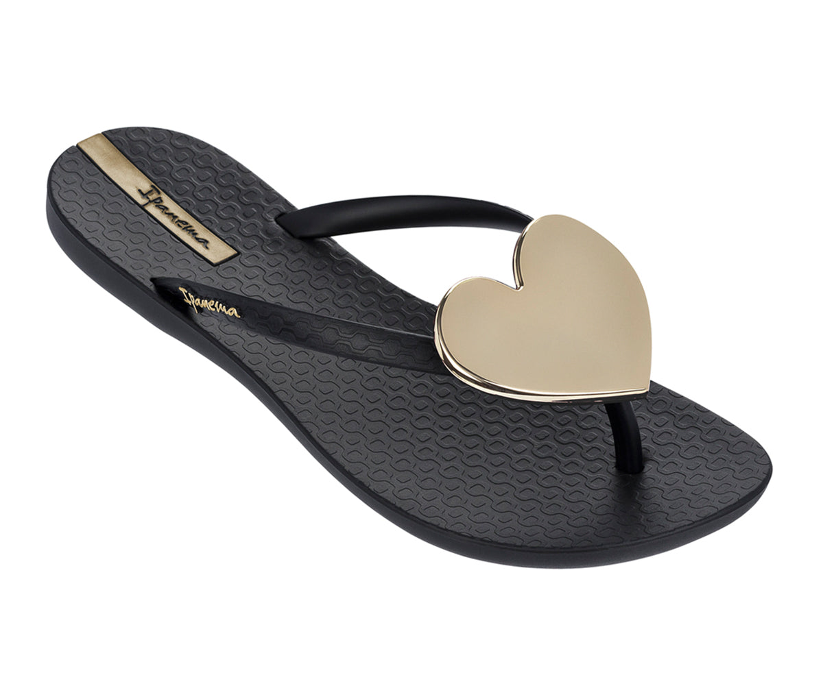 Angled view of a black Ipanema Wave Heart flip flops with a gold heart.