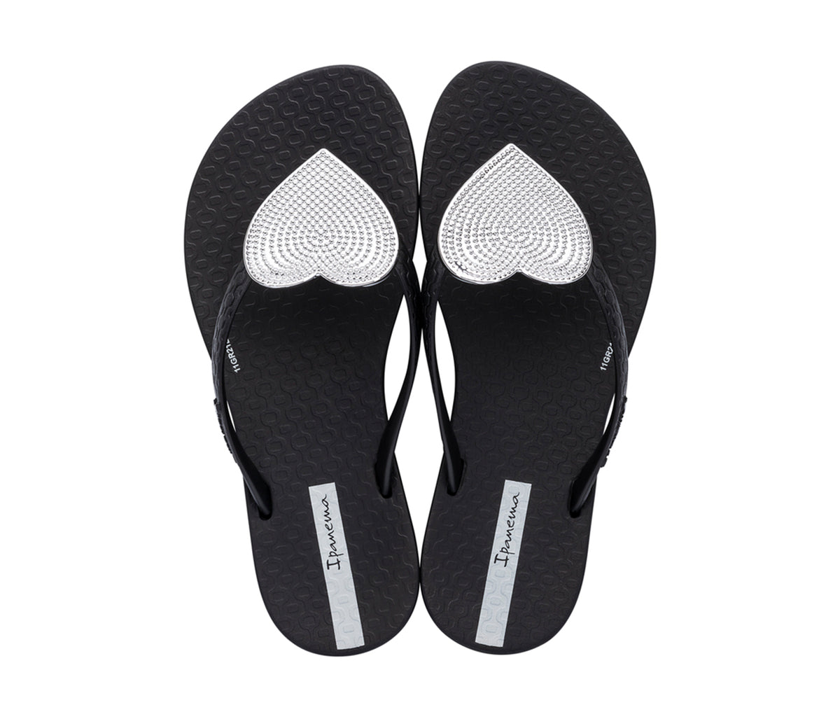 Top view of a pair of black Ipanema Wave Heart kids flip flops with a metallic Silver heart on top.
