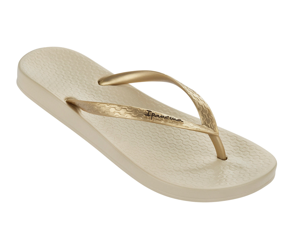 Angled view of a beige Ipanema Ana Colors kids flip flop with gold straps.